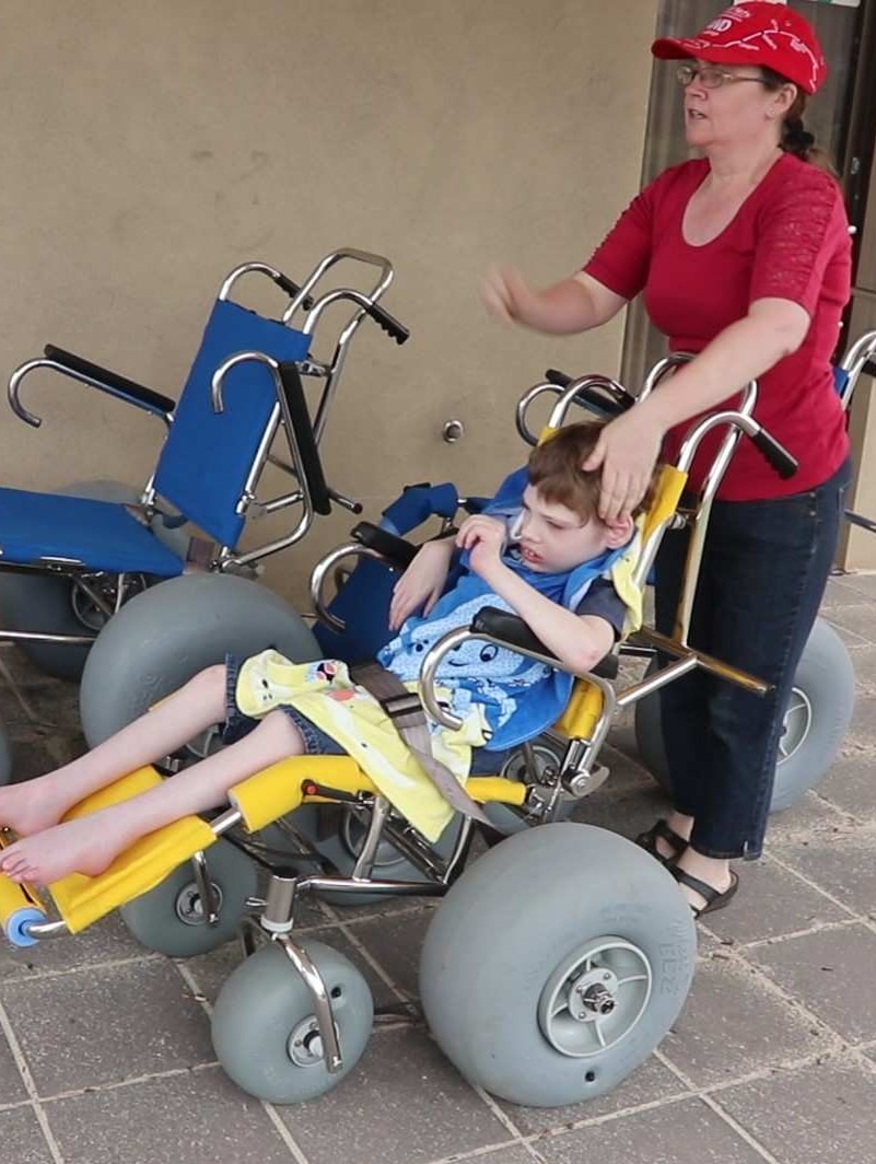 Boy strapped into wheelchair mum at the back on the left.