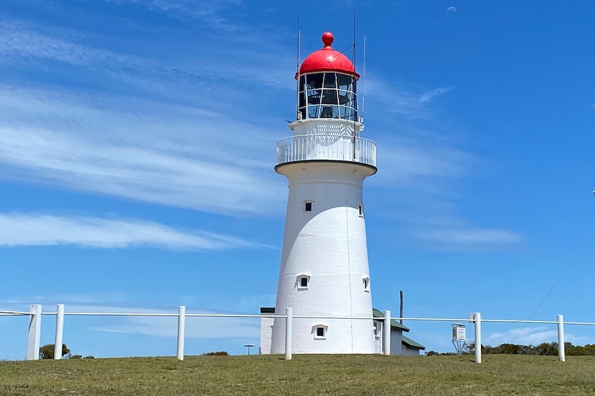 A lighthouse with blue sky in the background