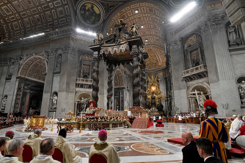 a wide image of inside St Peter's Basilica during Christmas Eve mass