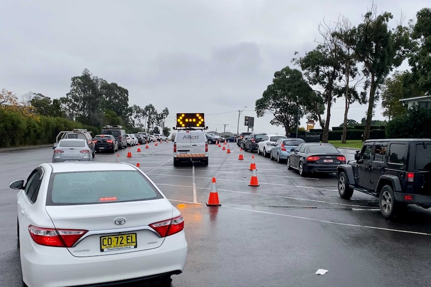 two lines of cars wait for a COVID swab in casula