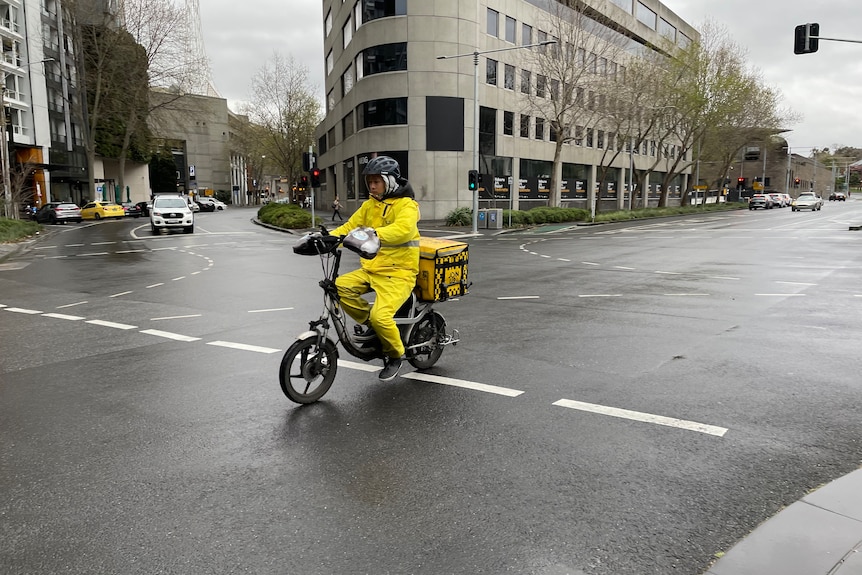 Gig worker in yellow jacket on bike