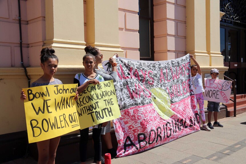 A woman and several children protest outside Kalgoorlie's town hall