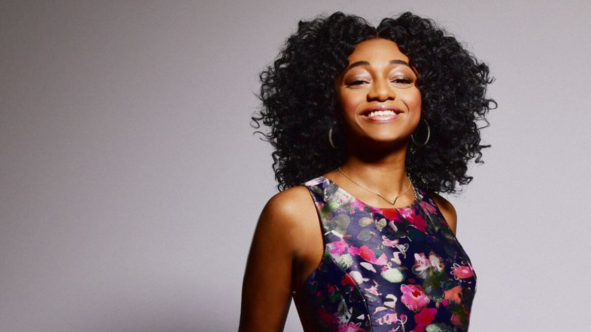 A colourful shot of Samara Joy in a floral dress