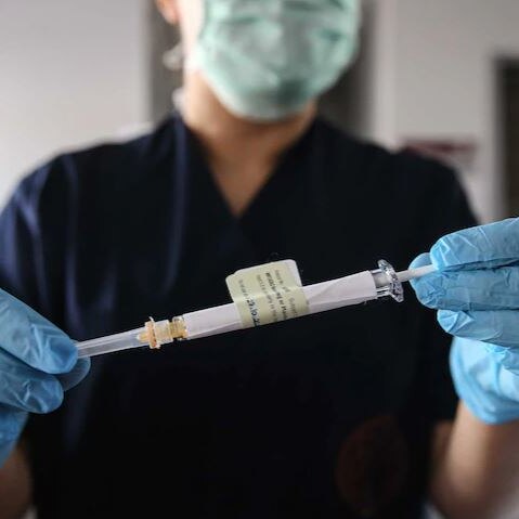 A nurse holds a dose of COVID-19 vaccine.