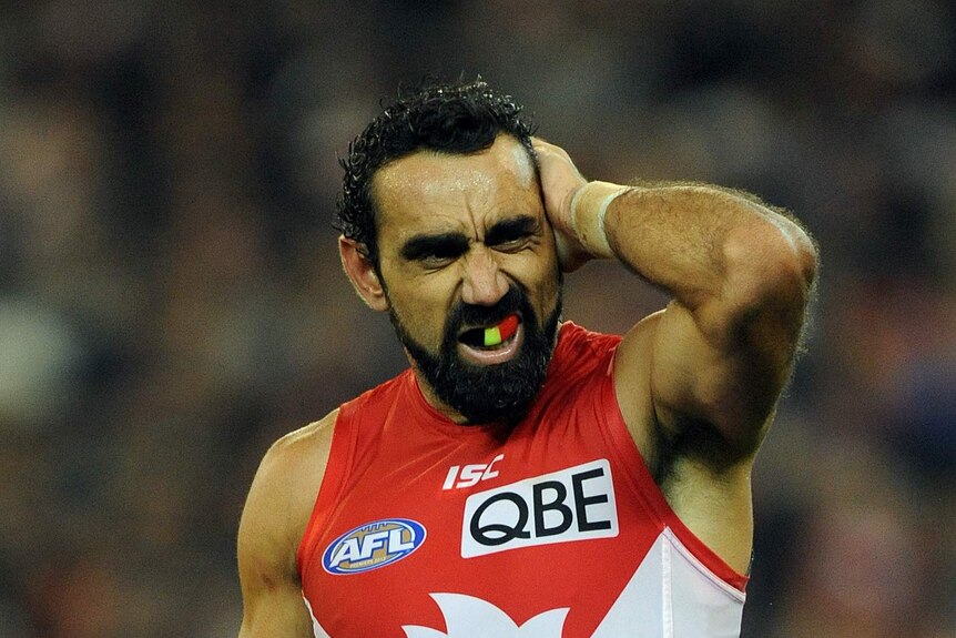 Goodes rubs his head at the G