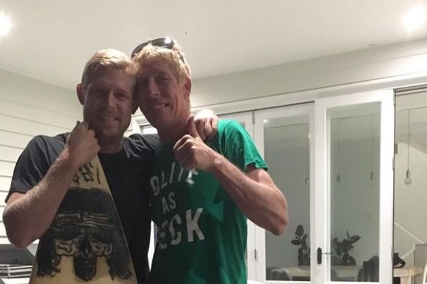 Surfing champion Mick Fanning with his brother Edward Fanning and a surfboard