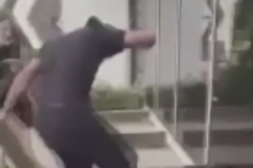 A man in black clothing appears to stomp on another man.