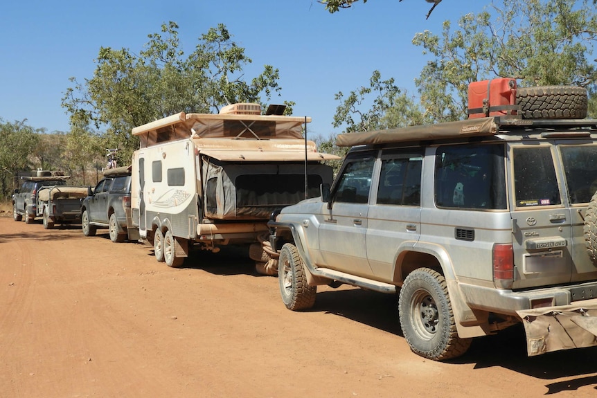 Caravans and four wheel drives parked in red dirt