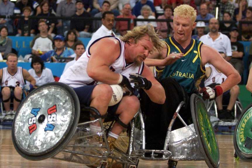 Two Paralympic wheelchair rugby players brace as their wheelchairs collide on court during the gold medal game.