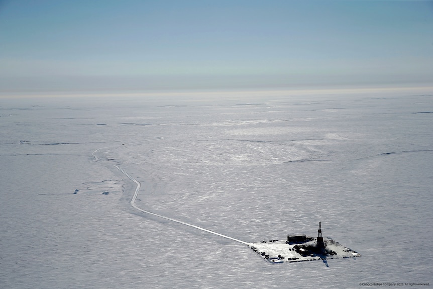 Aerial view of an oil mining facility on a flat, icy landscape