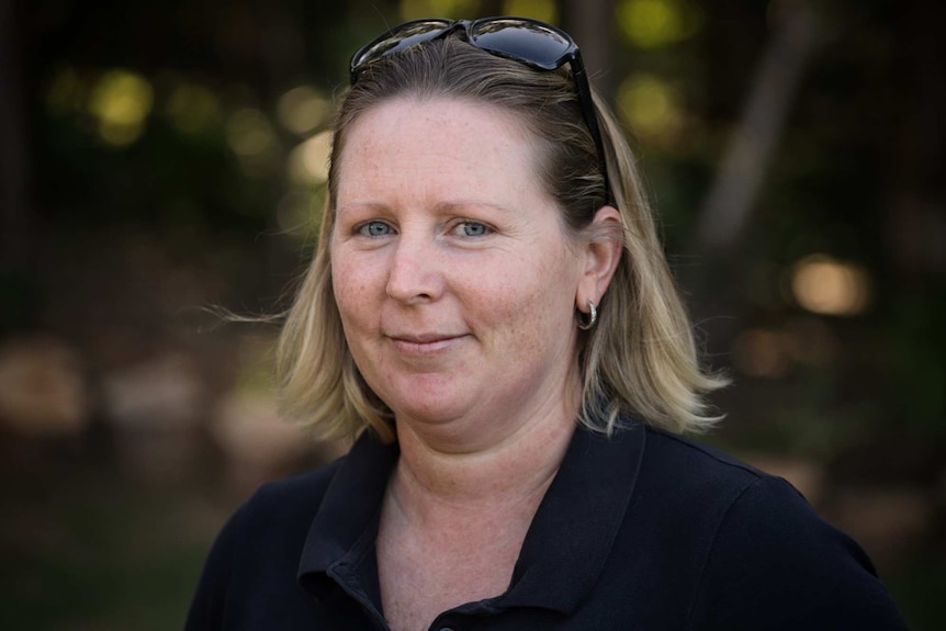 Headshot of Kristy Aitken, with sunglasses on her head.