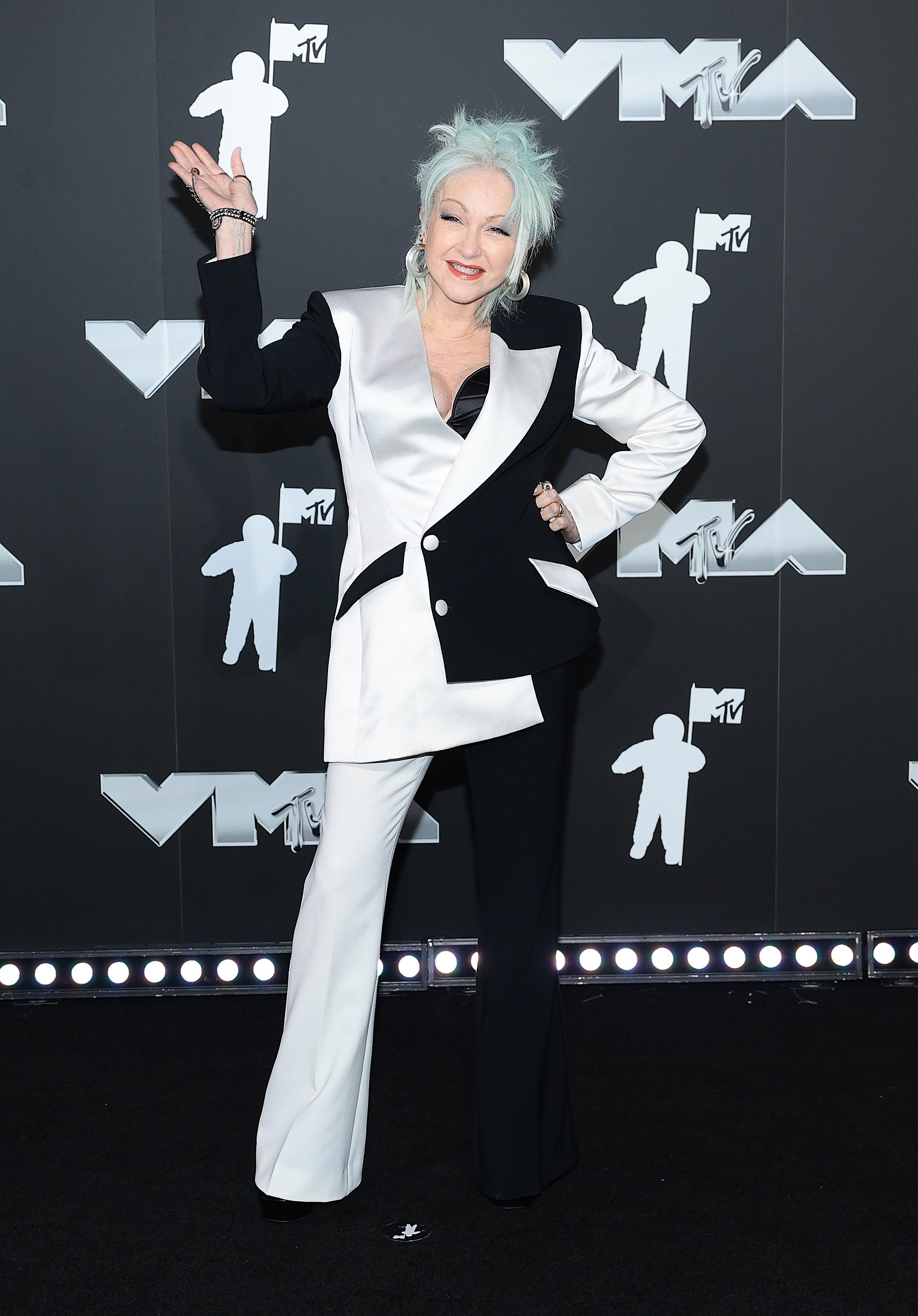 Cyndi Lauper wearing a black and white suit on the VMAs red carpet