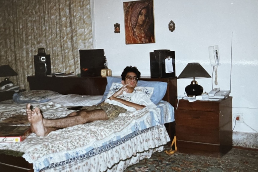 A teenage boy lies on a bed