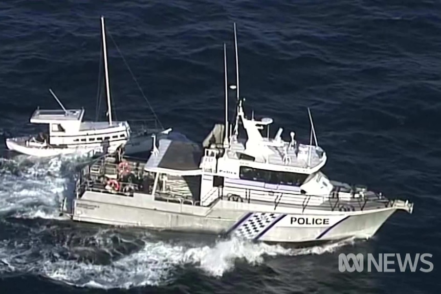 A police boat alongside a smaller fishing vessel in the ocean off South Australia
