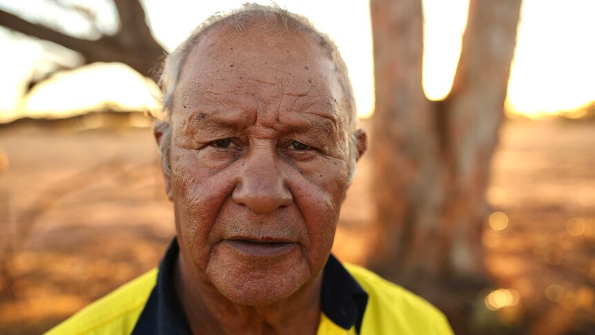 A headshot of Kevin Barron standing in the open with brown landscape in the background.