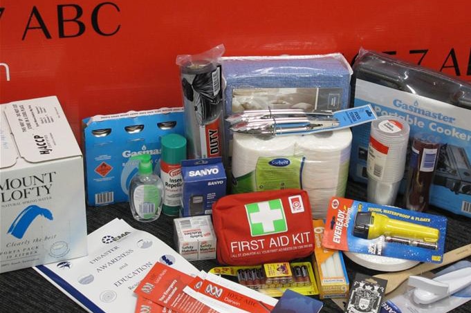 Items including a first aid kit sit on a bench.