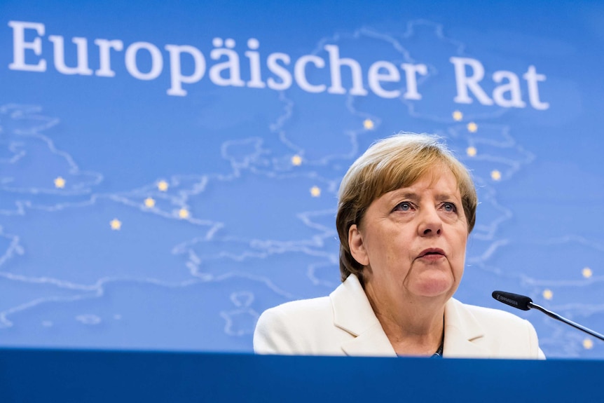 German Chancellor Angela Merkel speaks at a podium.
