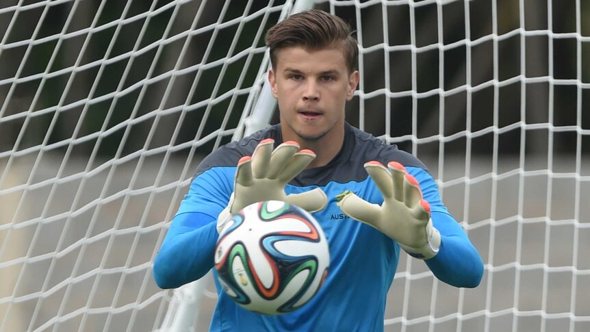Mitch Langerak watches a football arrive at his gloved hands