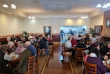 A crowd of people eat in a cafe