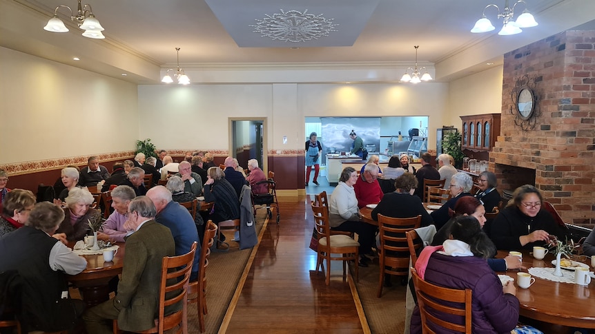 A crowd of people eat in a cafe