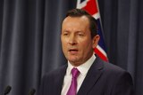 Head and shoulders shot of WA Premier Mark McGowan with a flag in the background.