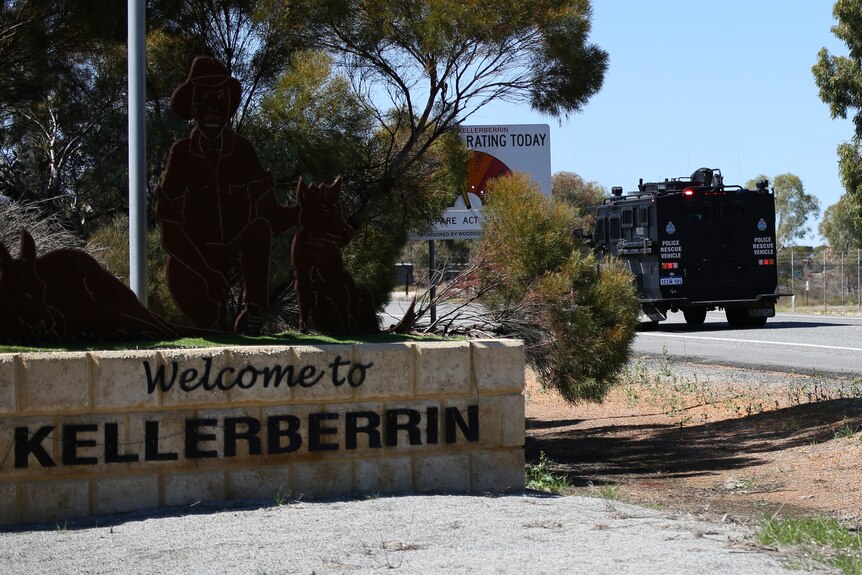 A sign that says welcome to Kellerberrin' with a heavy police vehicle rolling by. 