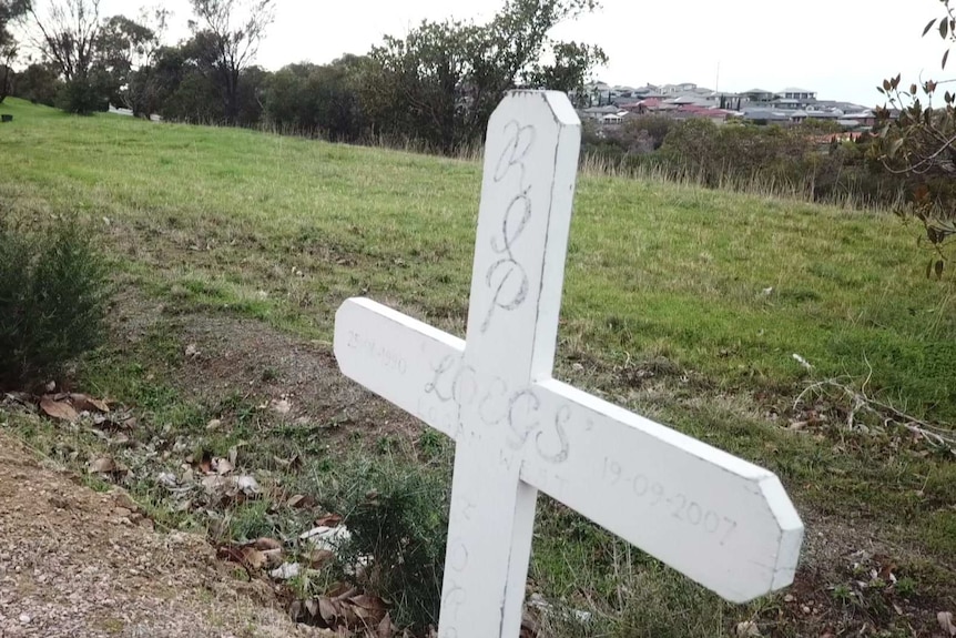 A memorial cross placed by the side of a road for Logan West