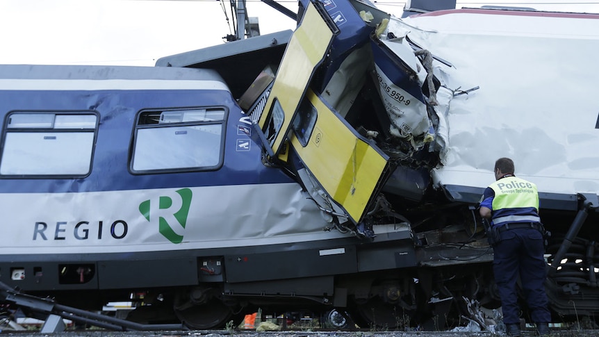 A police officer looks at the damage after a head-on collision between two trains in Switzerland.