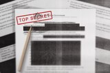 A redacted document with "Top Secret" stamped on the front page.