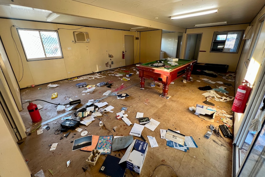 A large room strewn with rubbish and vandalism.