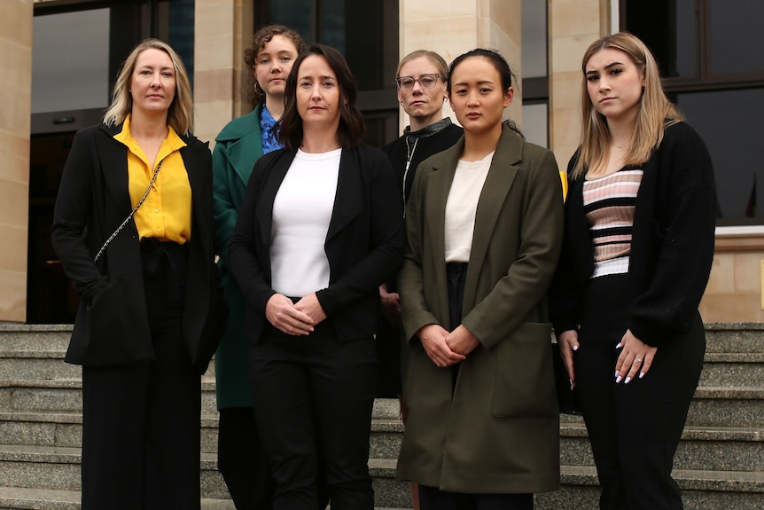 A group of six women pose for a photo outside the front entrance to the WA Parliament.