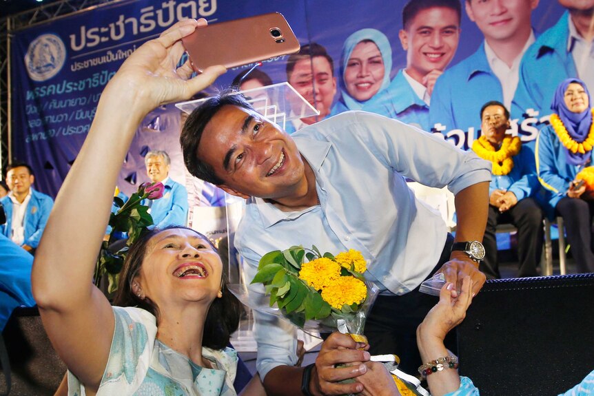 Thai politician Abhisit Vejjajiva poses for a selfie with a supporter