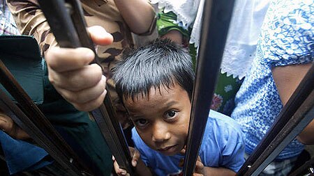 A boy waits for food at a refugee camp in Banda Aceh