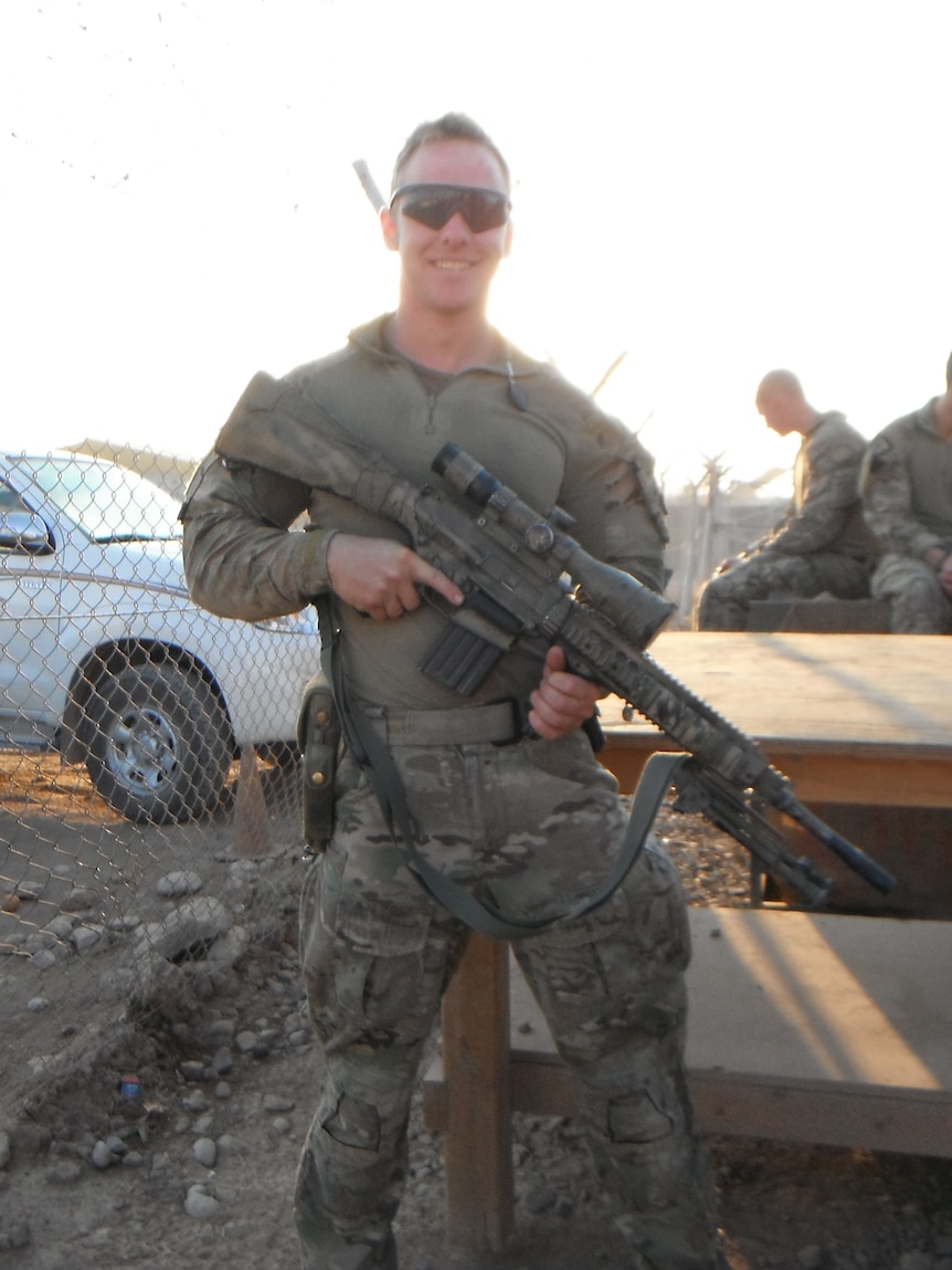 An Australian soldier holds a gun