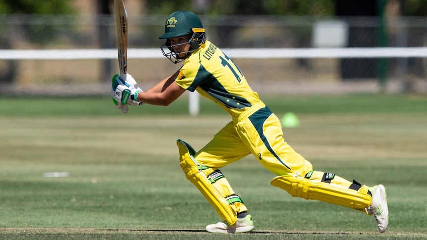 A teenage cricketer having just hit a ball at the crease