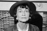 Coco Chanel poses for a photo on a plane at Paris airport