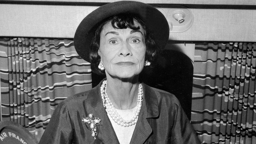 Coco Chanel poses for a photo on a plane at Paris airport
