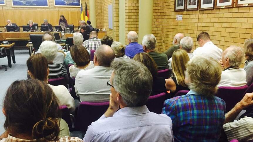 A large crowd of people sitting in the Coffs Harbour council chambers.