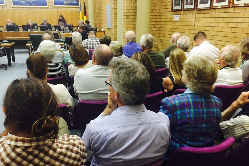 A large crowd of people sitting in the Coffs Harbour council chambers.