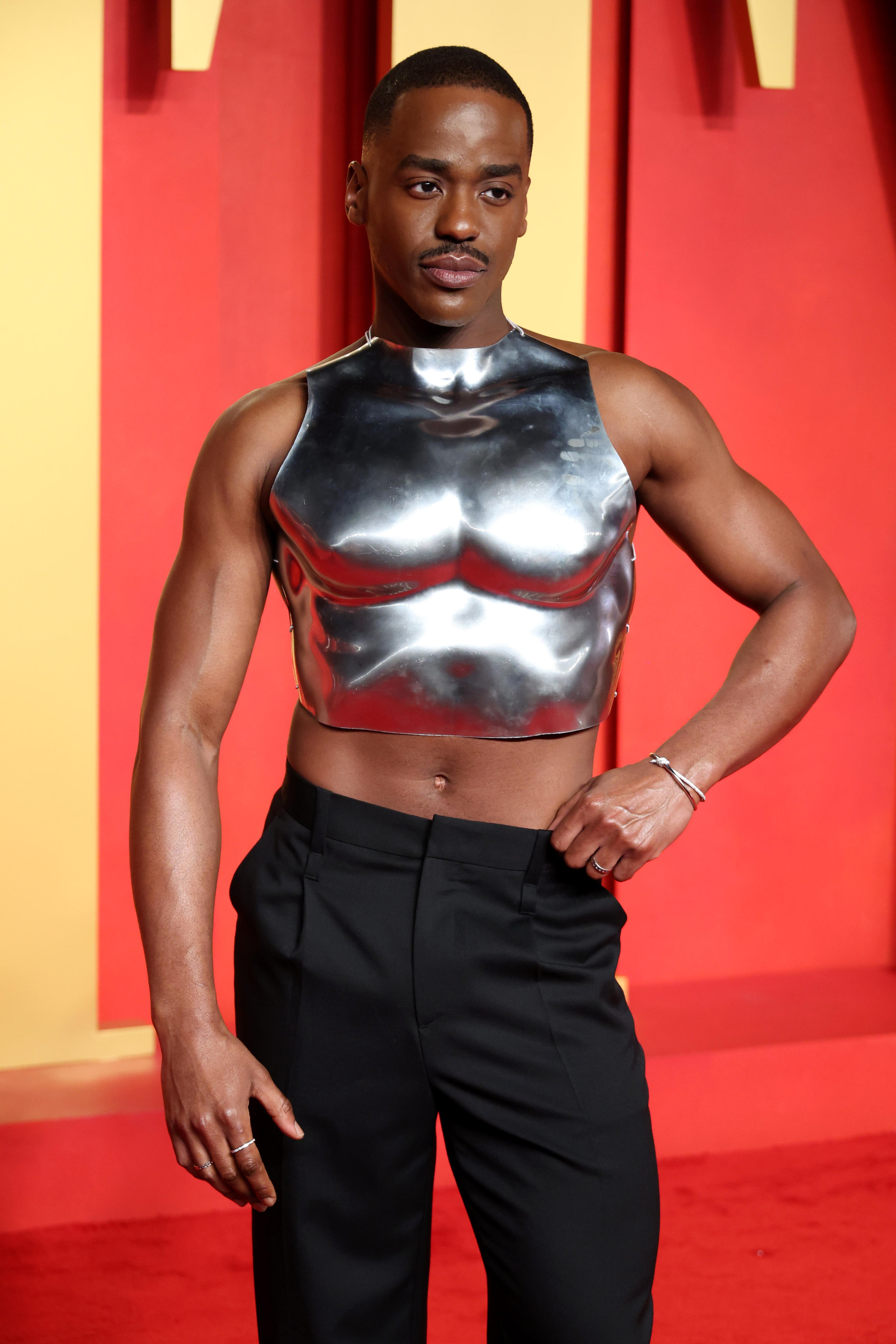 Ncuti Gatwa wears a silver crop top and black slacks.