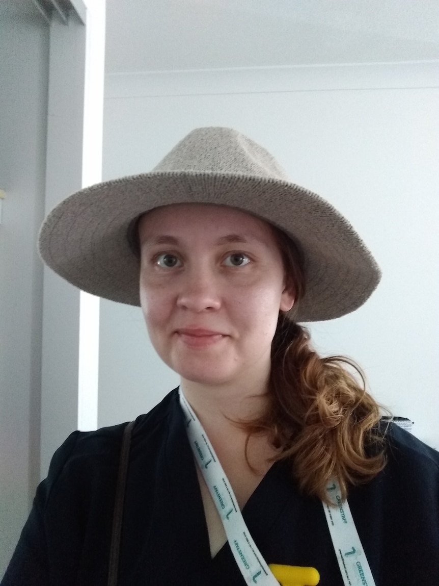 A woman wearing a hat and white lannyard. 
