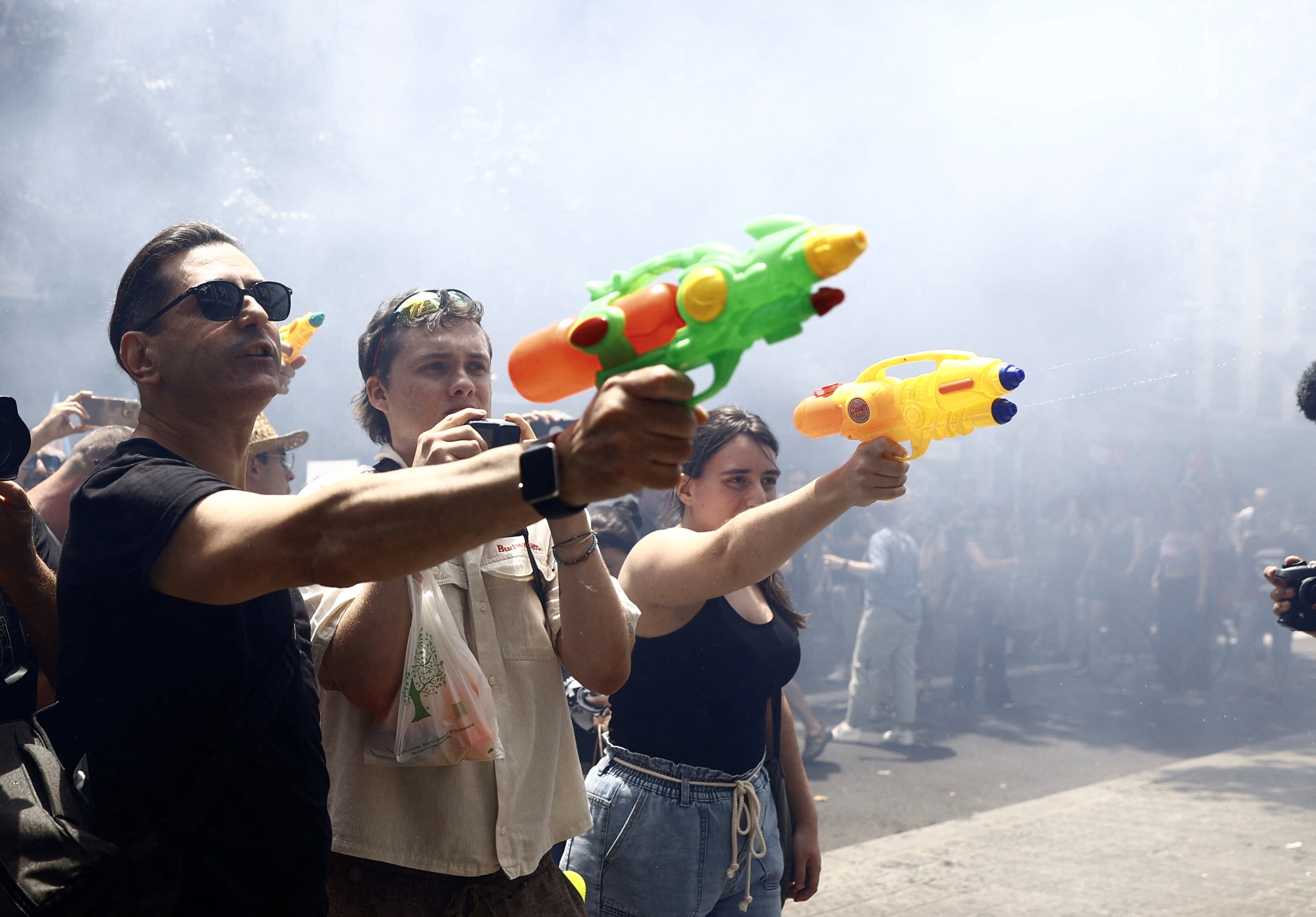 People shoot water pistols during a protest.