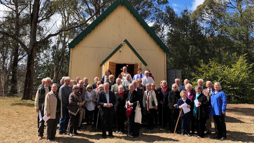 Parishioners at St Aidan's Church gather outside the doors after officially reopening it