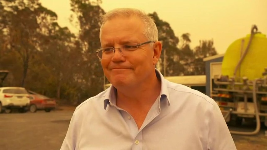 A man grins under an orange sky