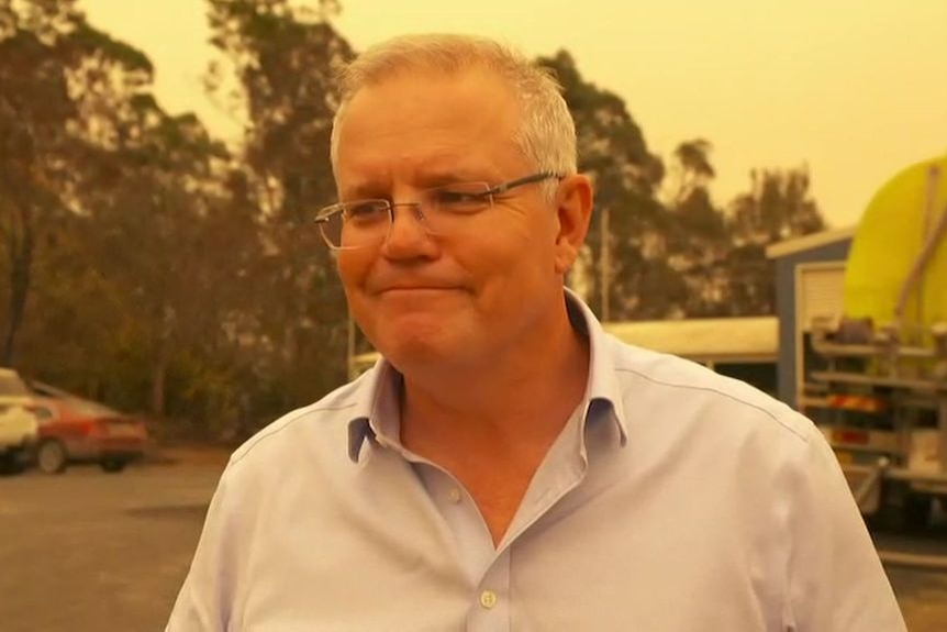 A man grins under an orange sky