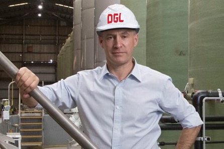 A man wears a construction hat inside a factory.