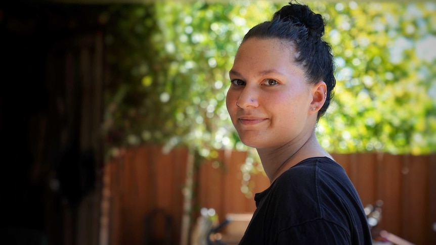 Cheyenne Maymuru, 19, stands in her backyard in Cairns.