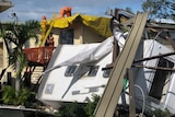 Clean up crews check a house next to a destroyed caravan in Lennox Head