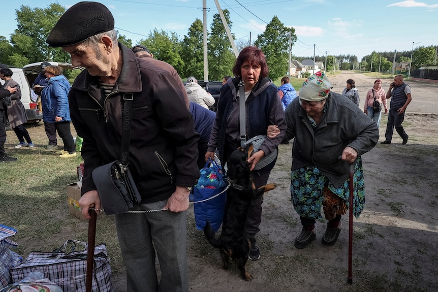 Residents from Vovchansk and nearby villages wait for buses.