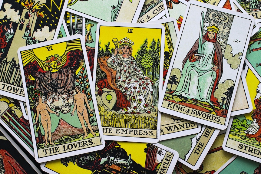 A close up of tarot cards showing the lovers, the empress and king of swords.